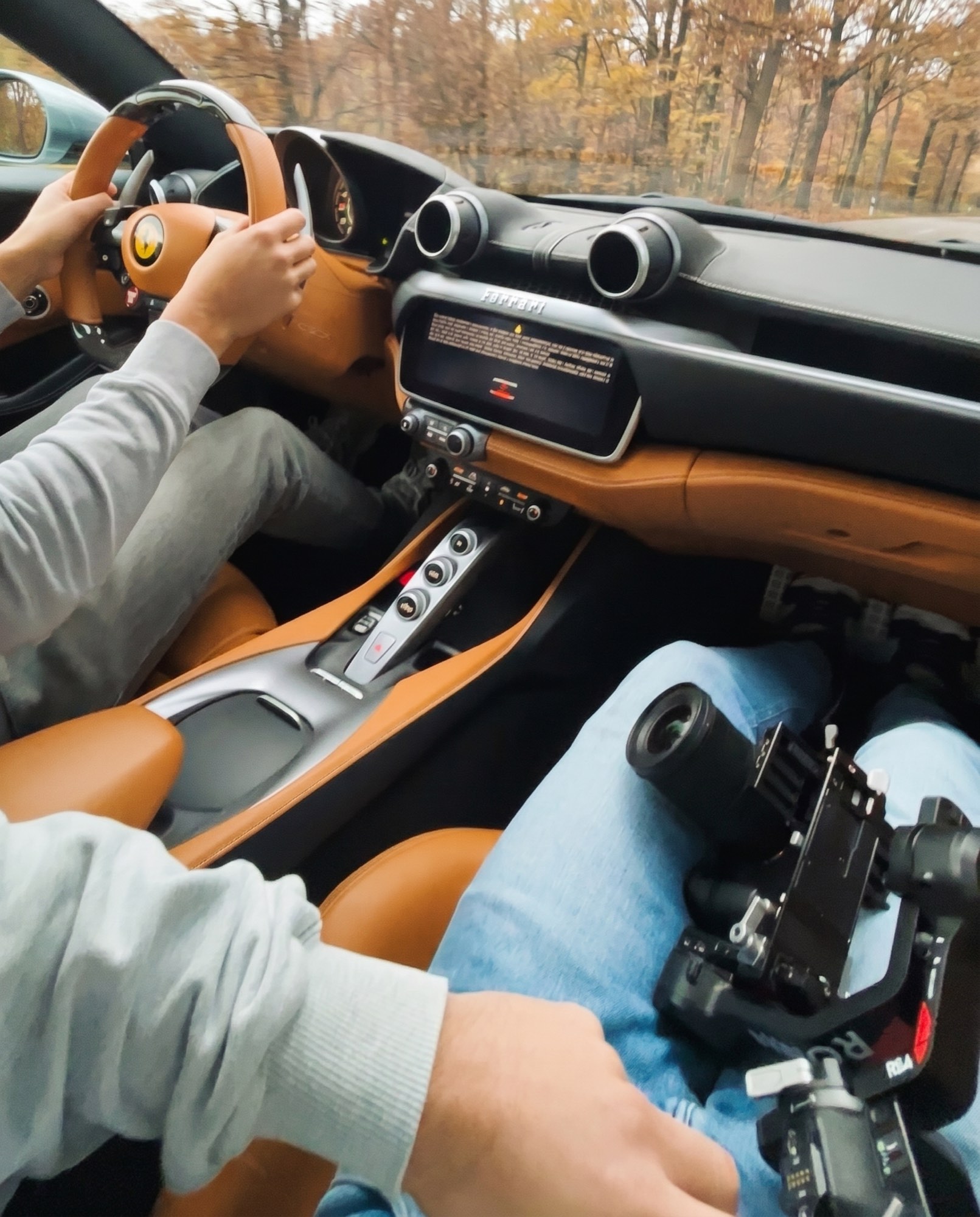 Gimbal met camera op schoot tijdens een rijshoot in een Ferrari
