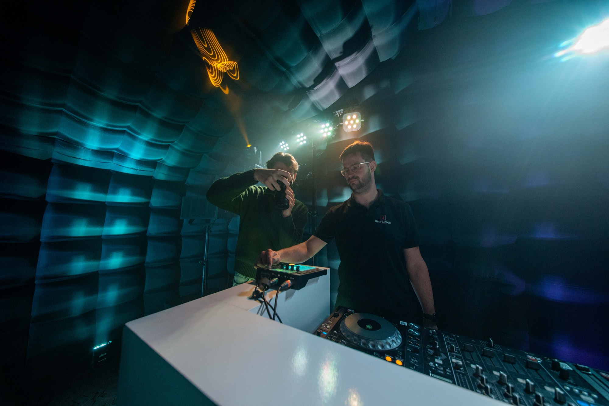 Achter de schermen: de crew filmt een dj-booth in blauw en teal licht