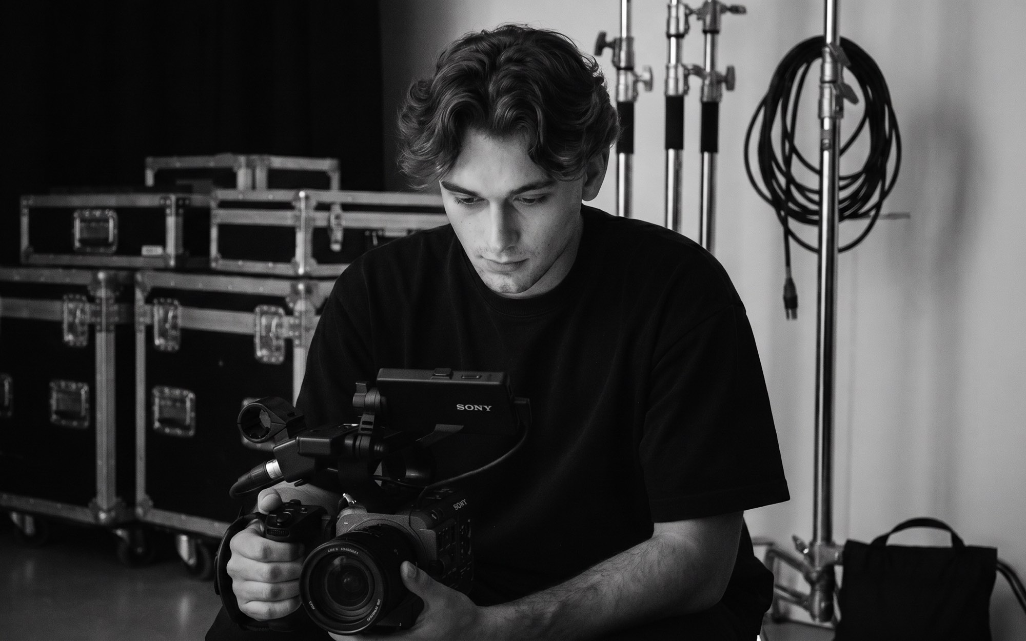 Achter de schermen in de studio: cameraman met cinema-camera tussen de flightcases