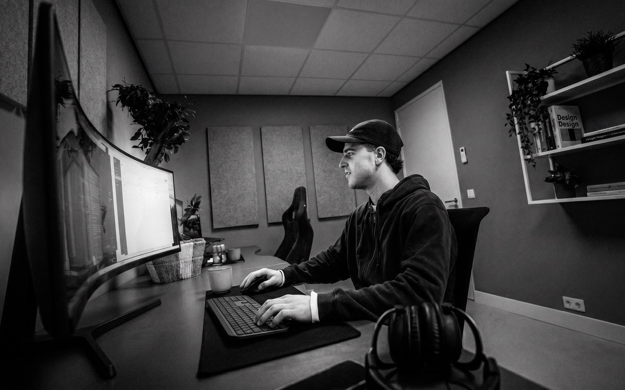 Editor werkt aan beeldmateriaal op een ultrawide monitor in de editruimte