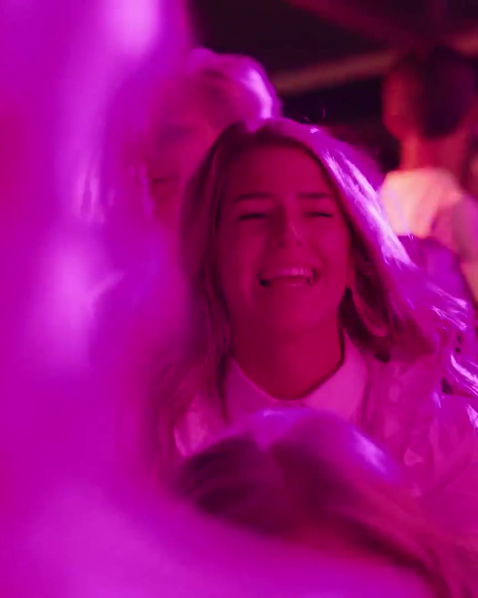 Dansende gast in roze licht tijdens het avondfeest