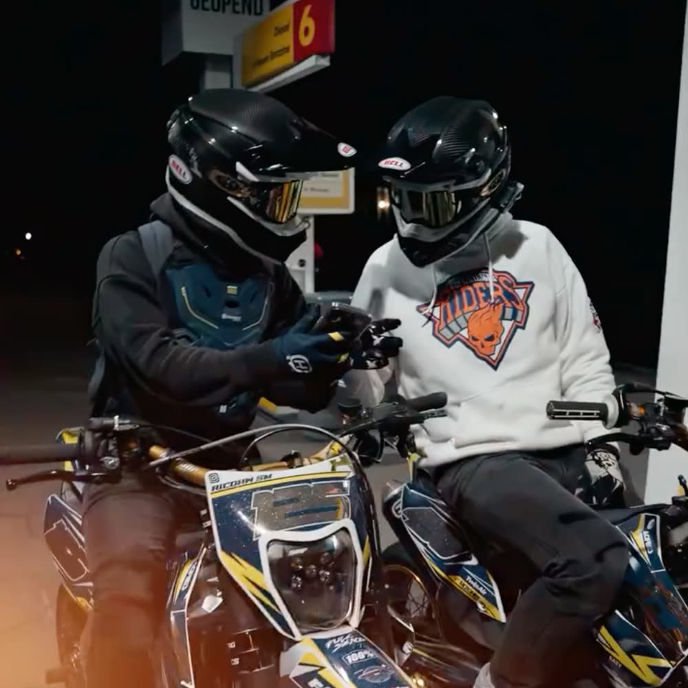 Twee rijders bij het tankstation in de nacht