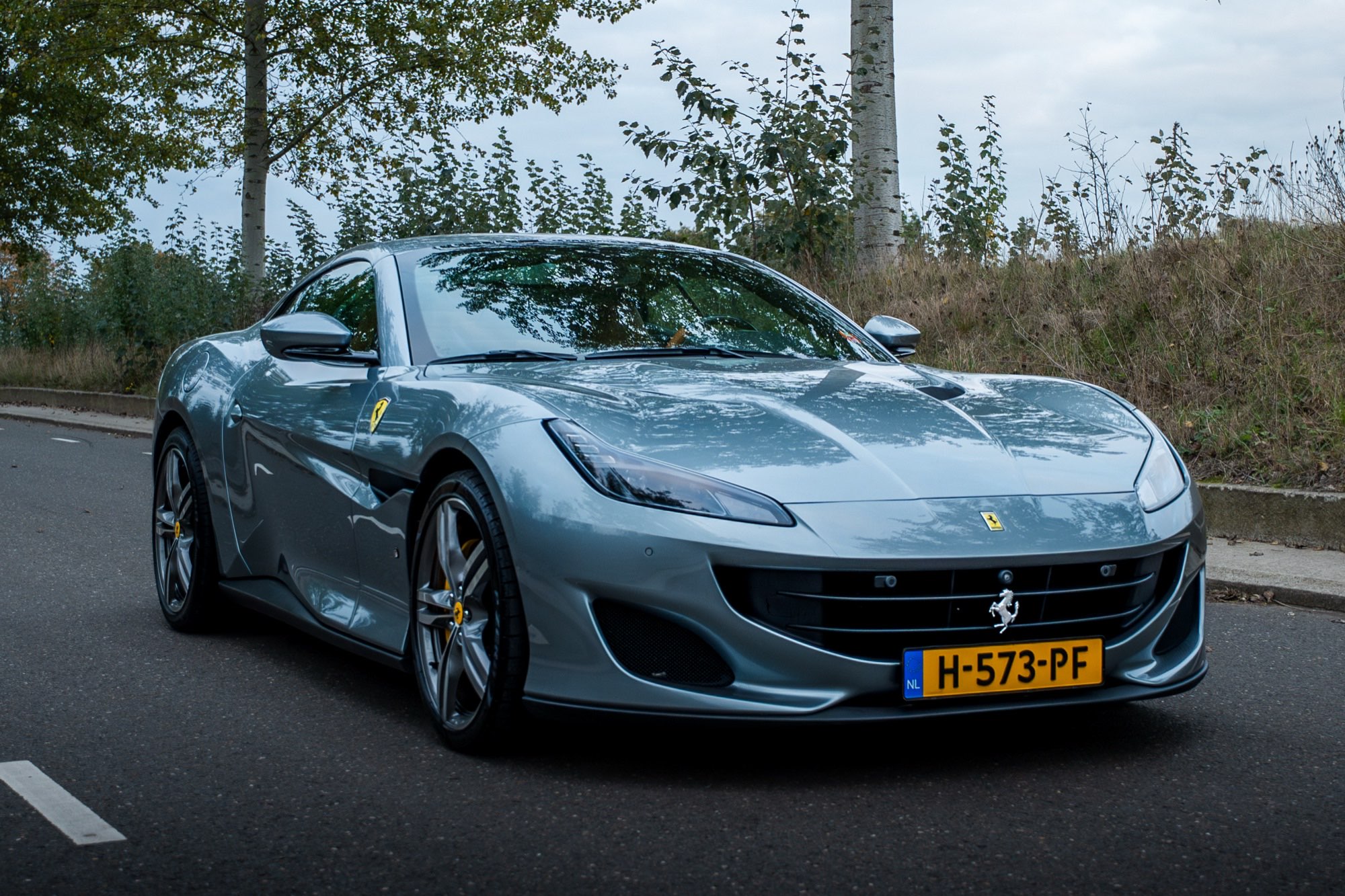 Lichtblauwe Ferrari Portofino schuin vooraan op straat, gedetaild door Jott
