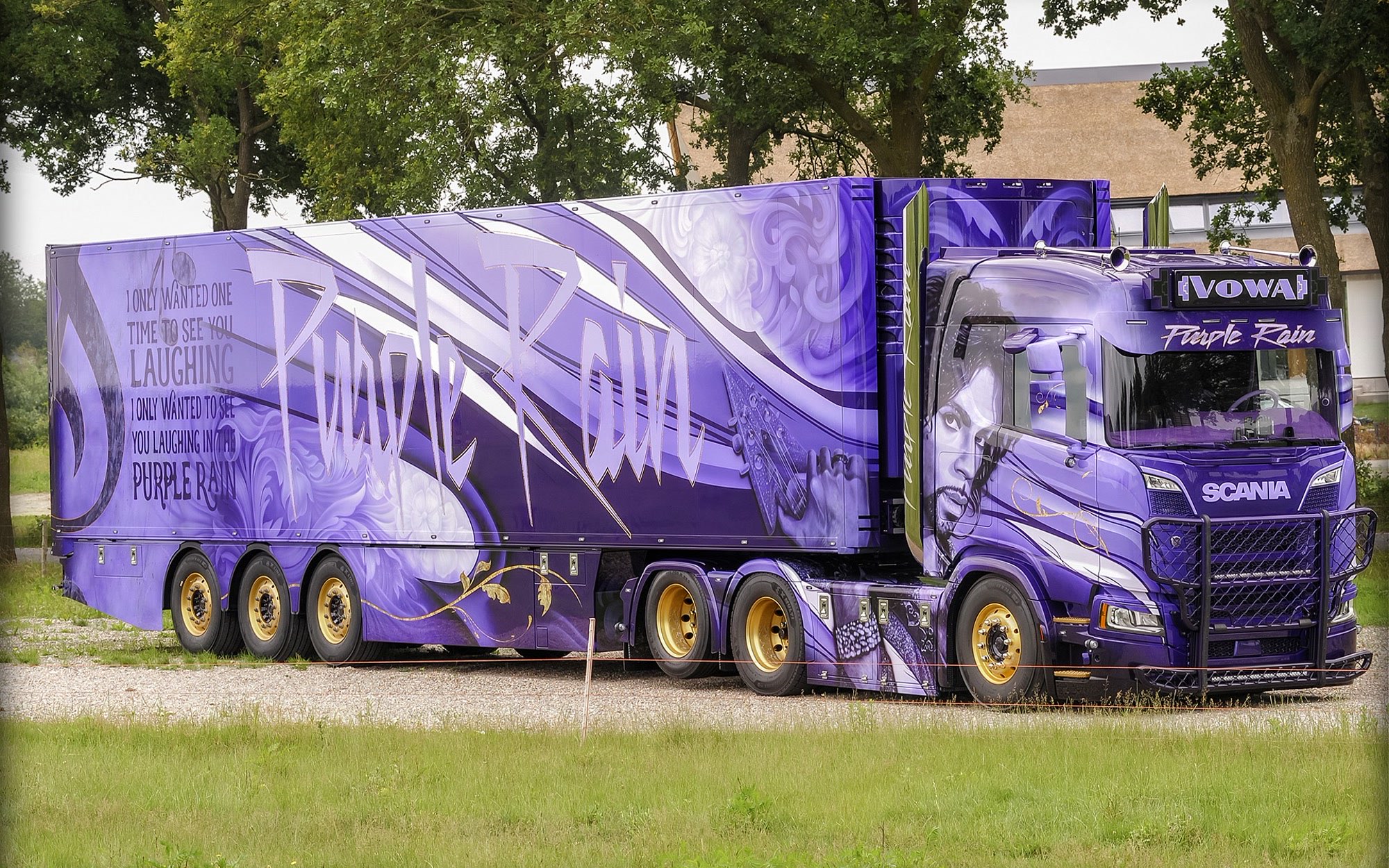Driekwart-totaal van de complete Purple Rain-truck plus oplegger op het gras