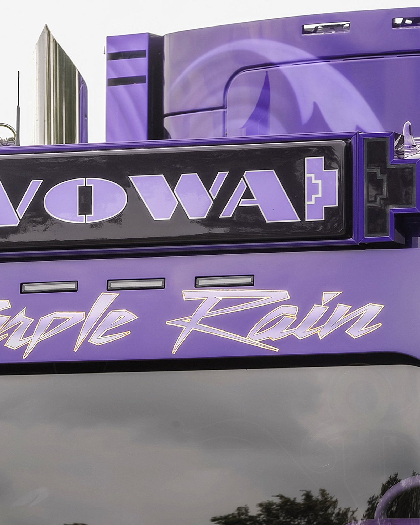 Het verlichte VOWA-naambord met chroom-gouden Purple Rain-script op de zonneklep