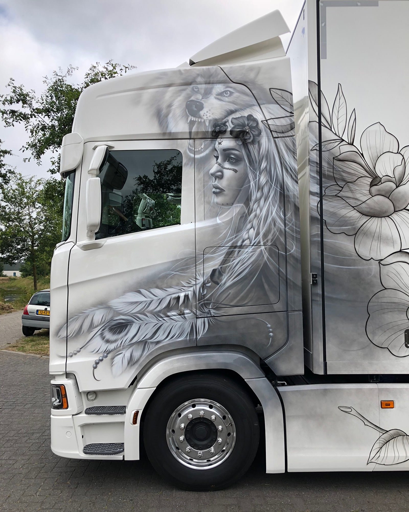 Witte Scania met grijswaardig airbrushwerk van een wolf en een vrouw