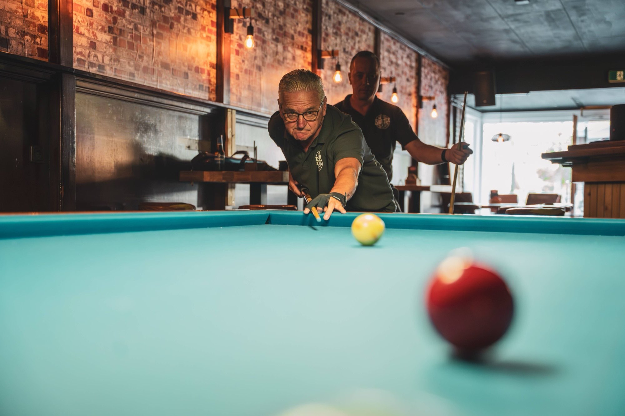 Wijd sfeerbeeld van het volle poolcafe