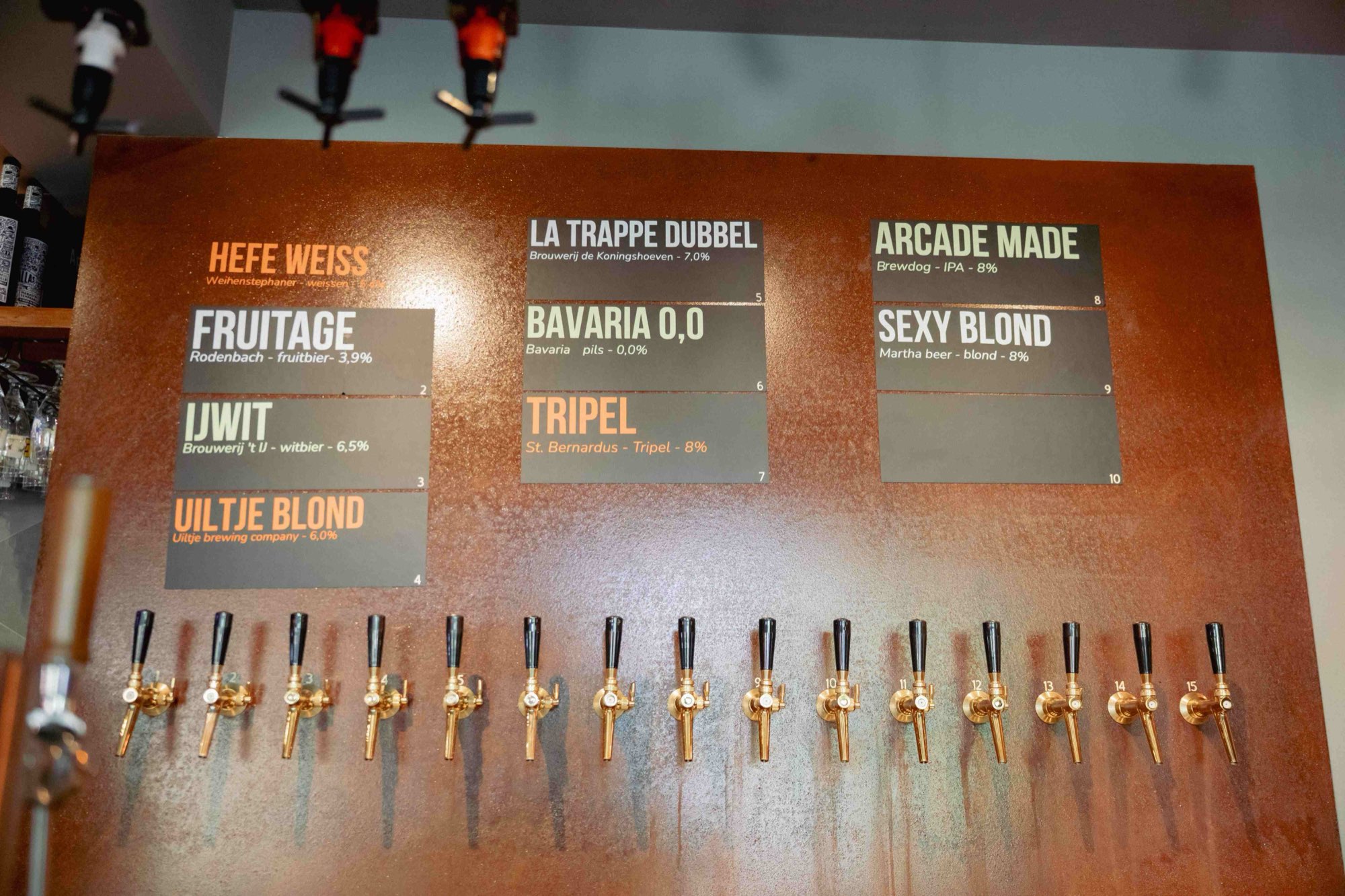 Koperen tapwand met gouden biertappen en de bierkaart