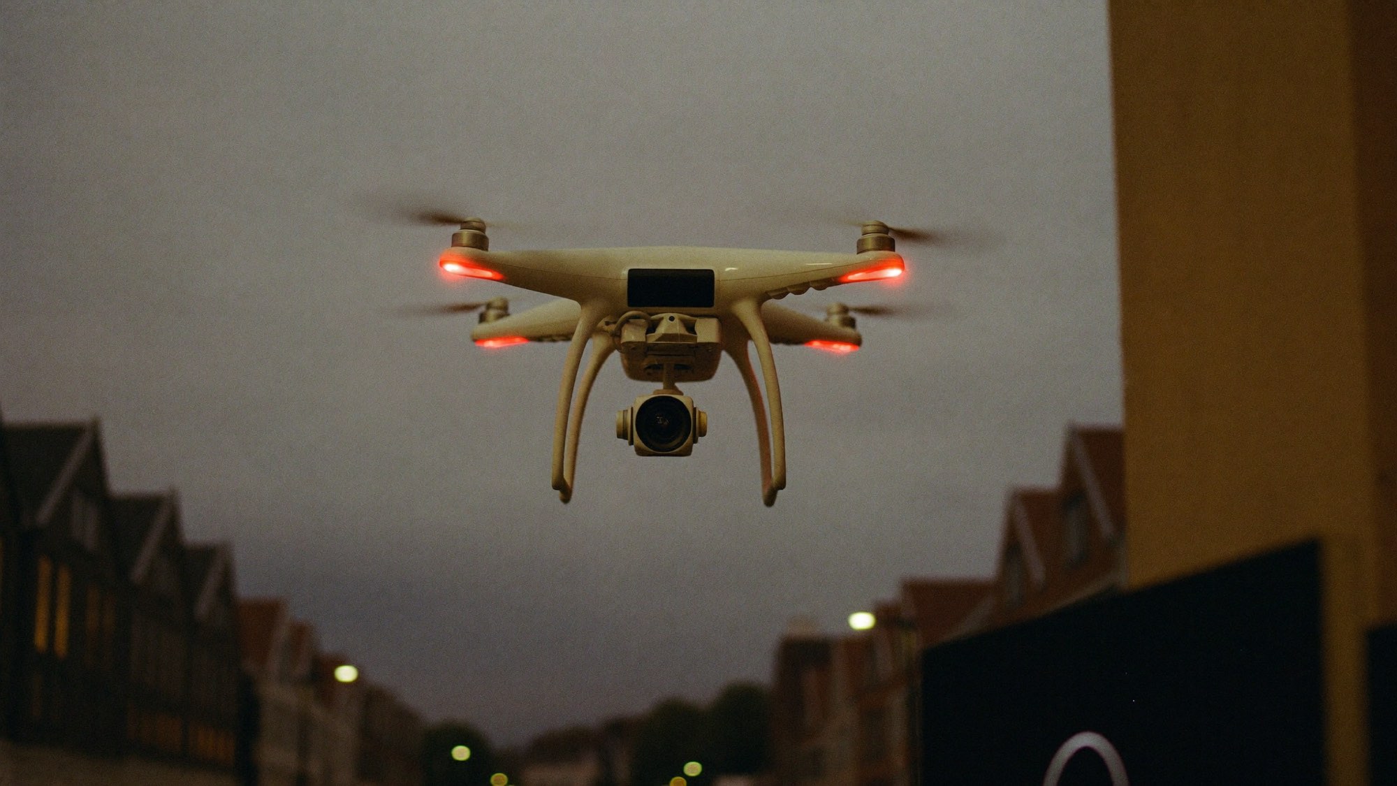 Camera-drone in de lucht boven een straat in de schemering