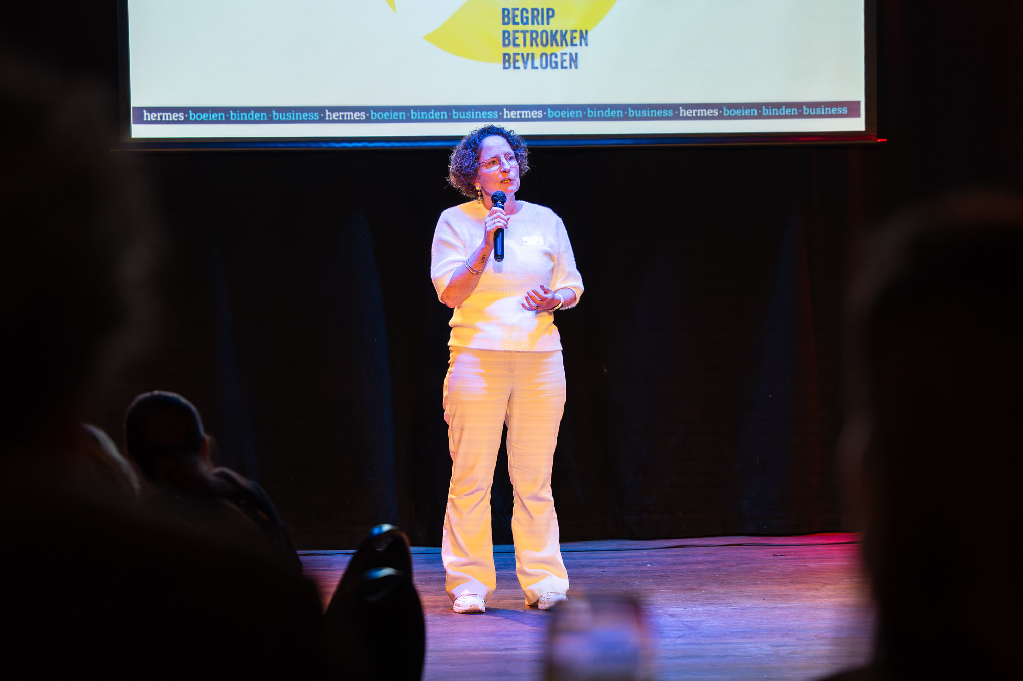 Spreker op podium met Hermes branding