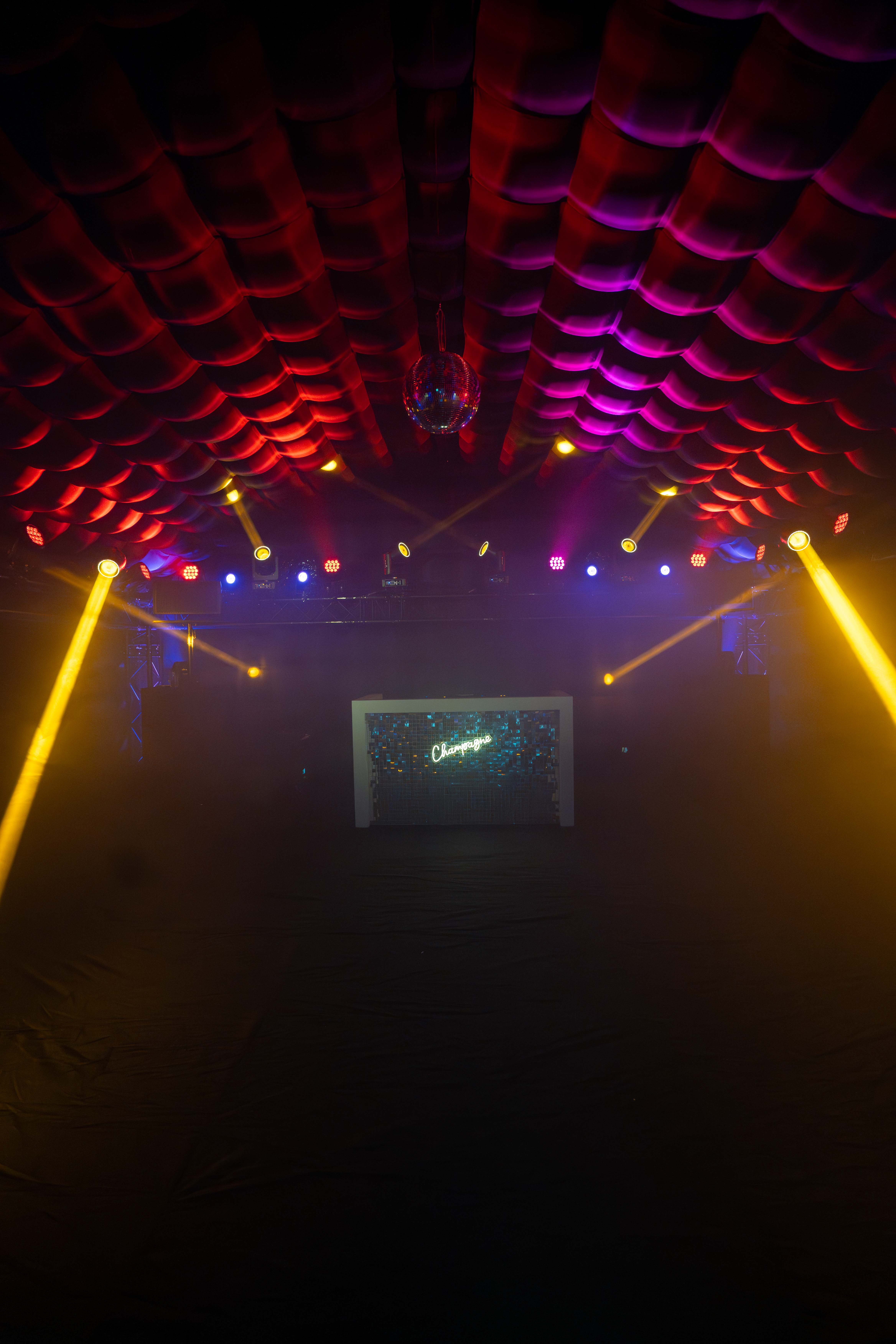 Interieur met rode en paarse verlichting en champagne wall