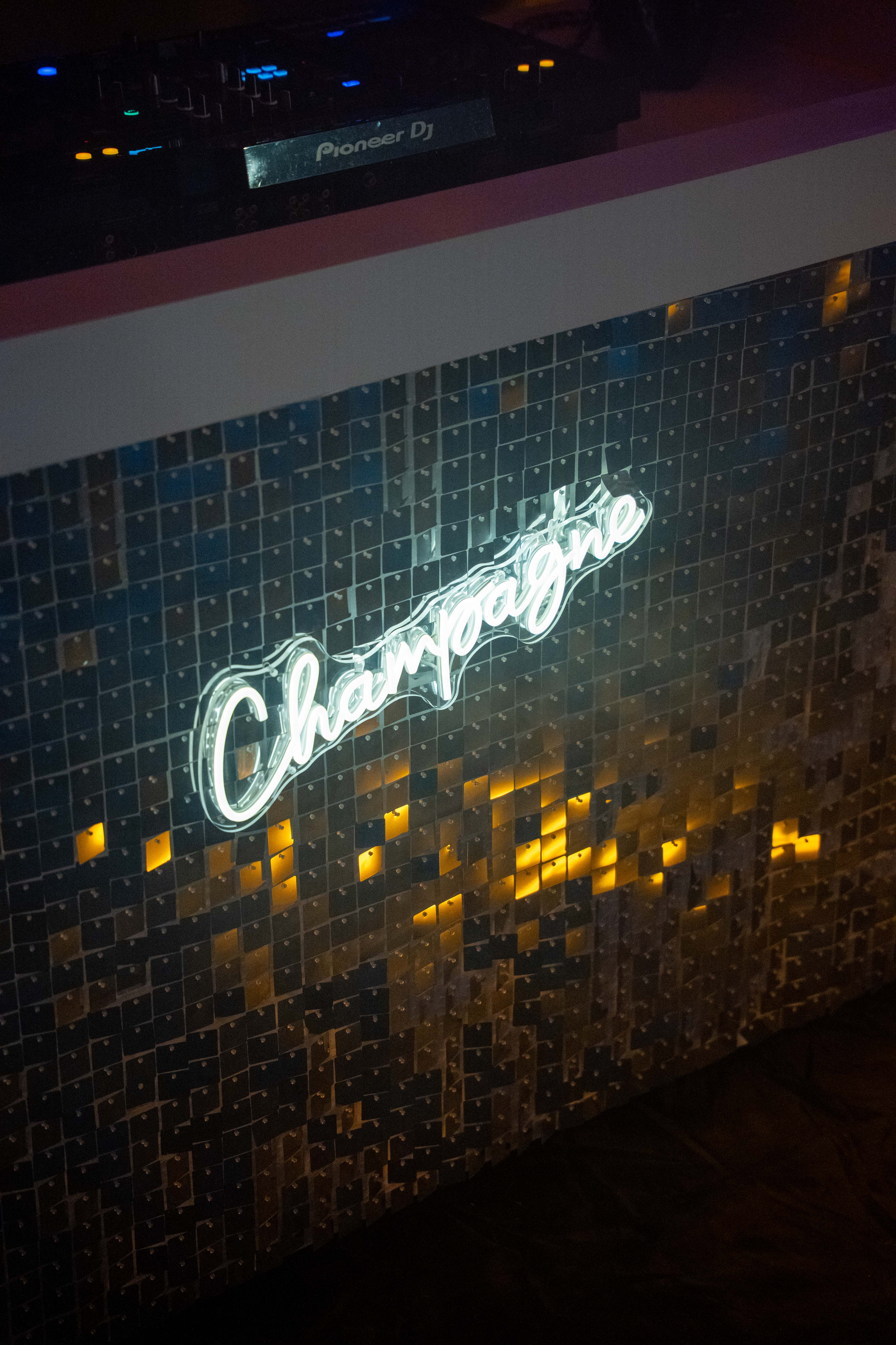 Champagne neon sign achter de DJ-booth