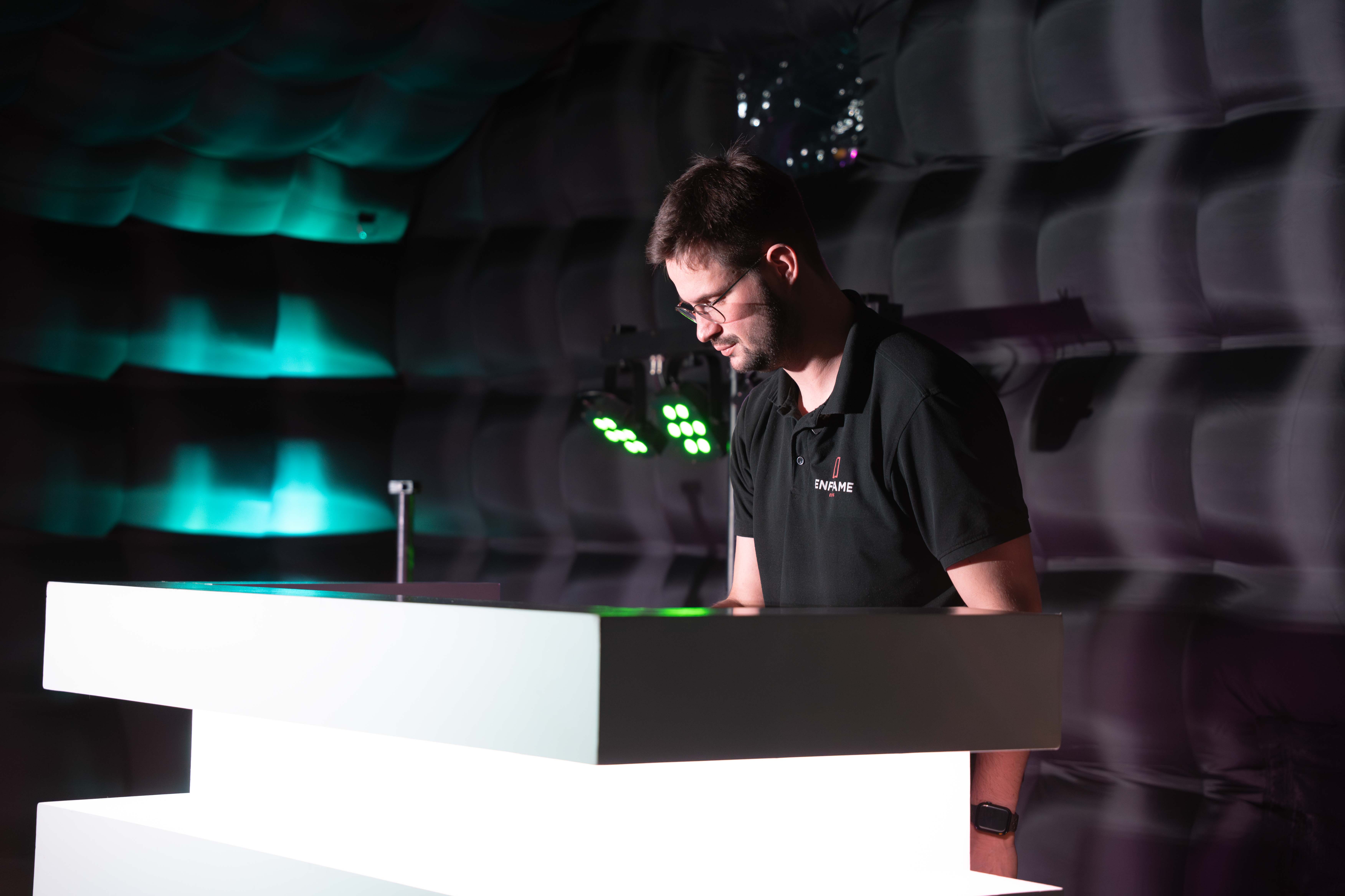 DJ geconcentreerd achter de booth met groene verlichting