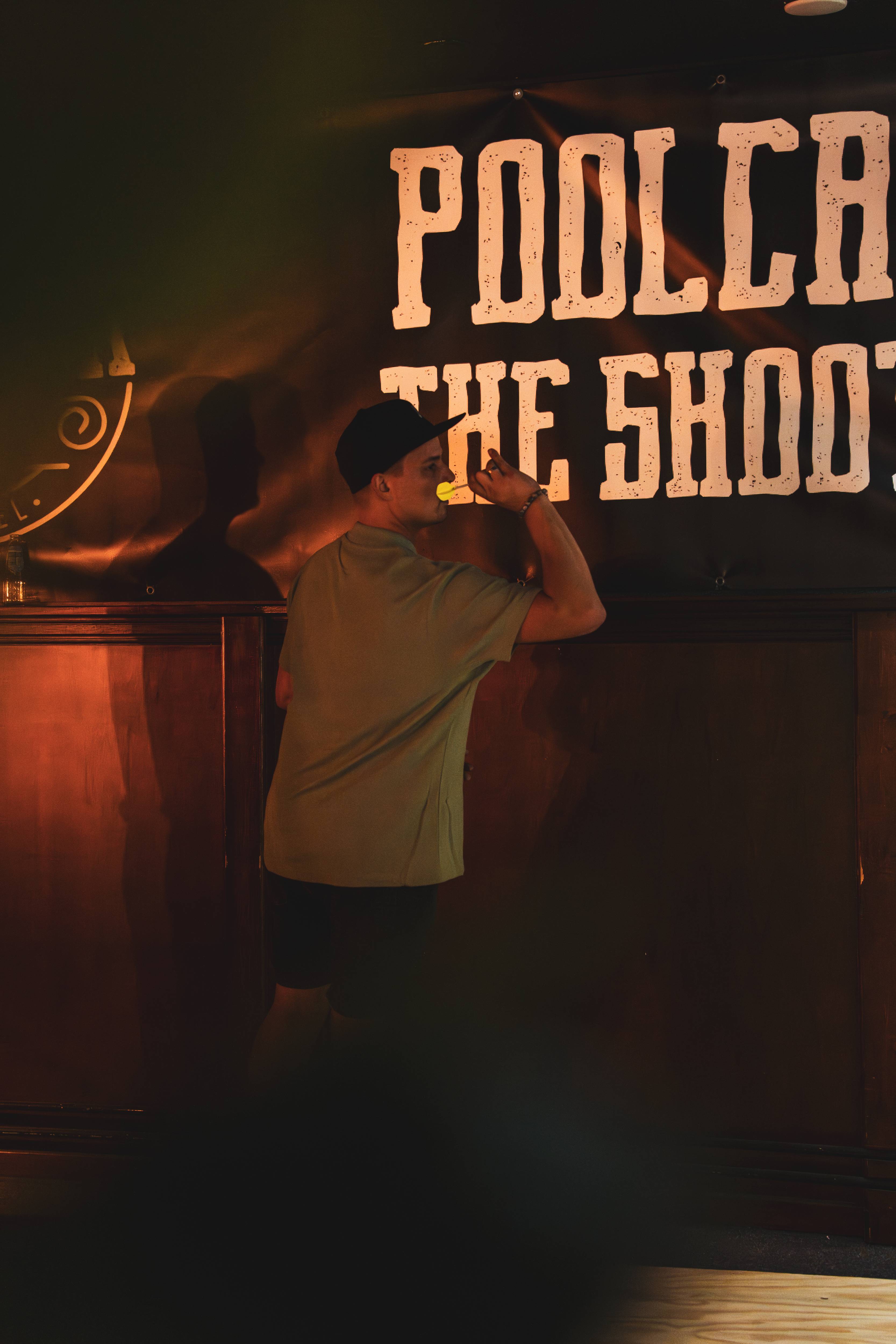 Gast gooit dart bij Poolcafe The Shooter banner