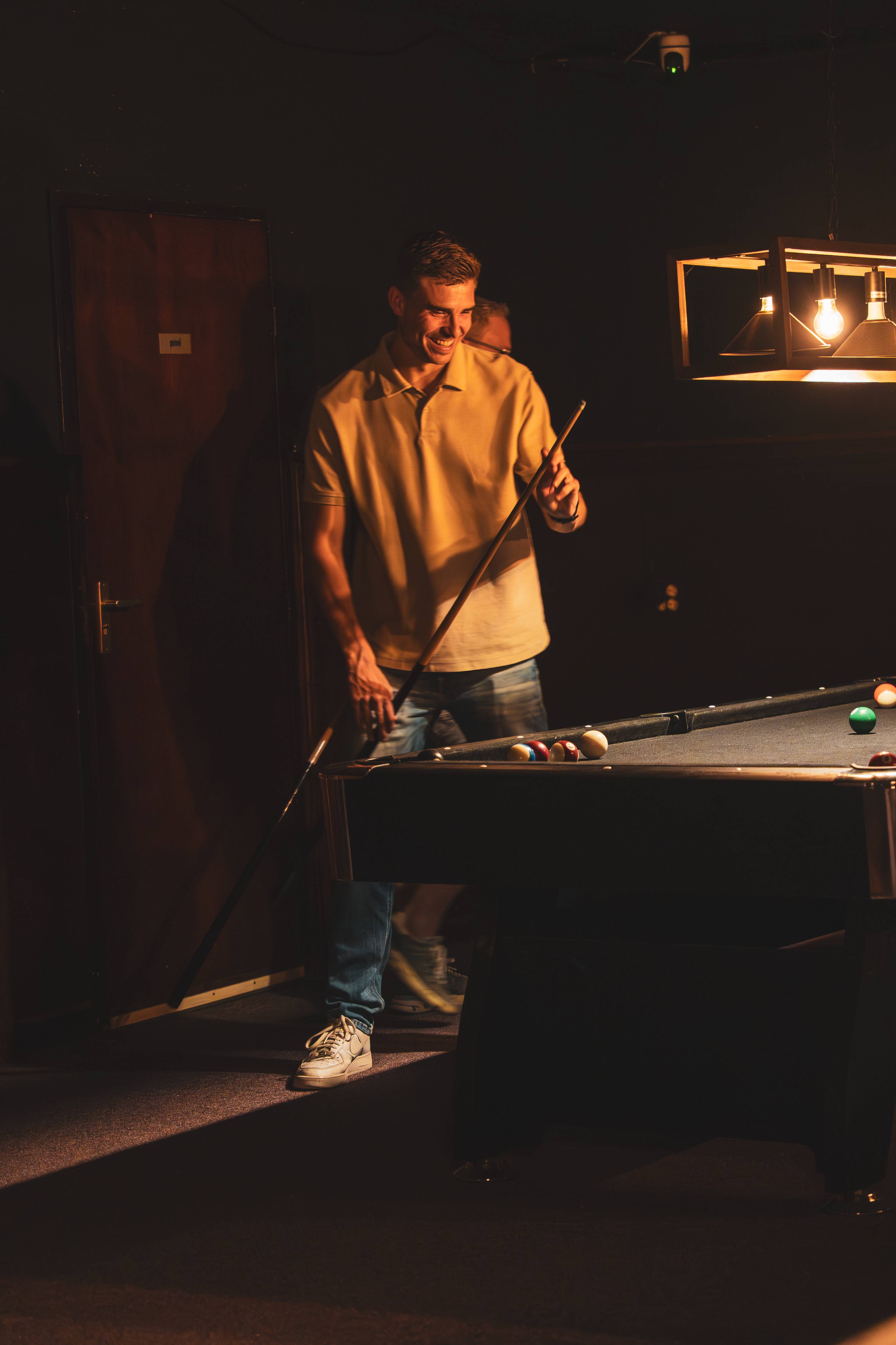 Poolspeler staand bij de tafel met keu