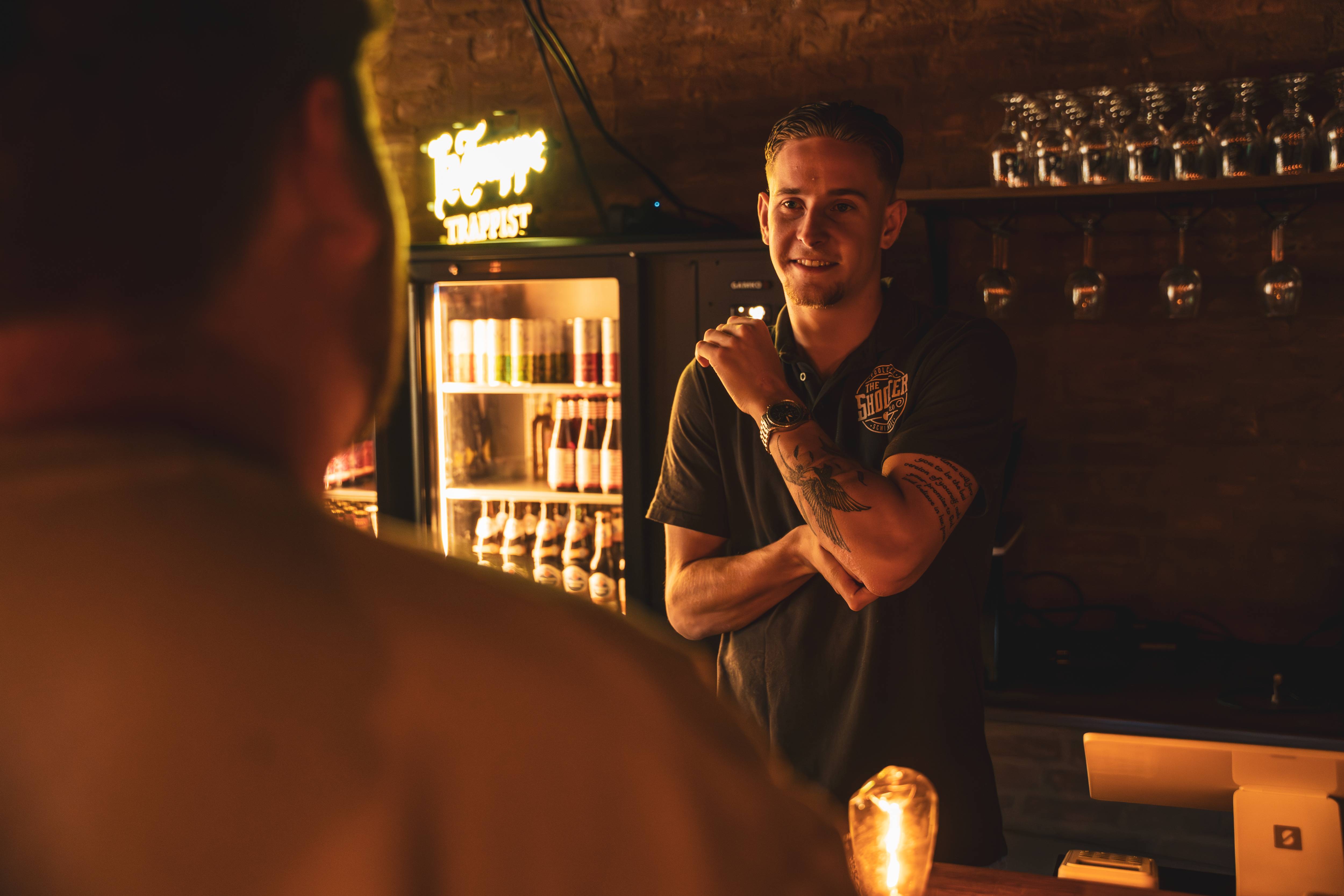 Barman in gesprek met gast aan de bar