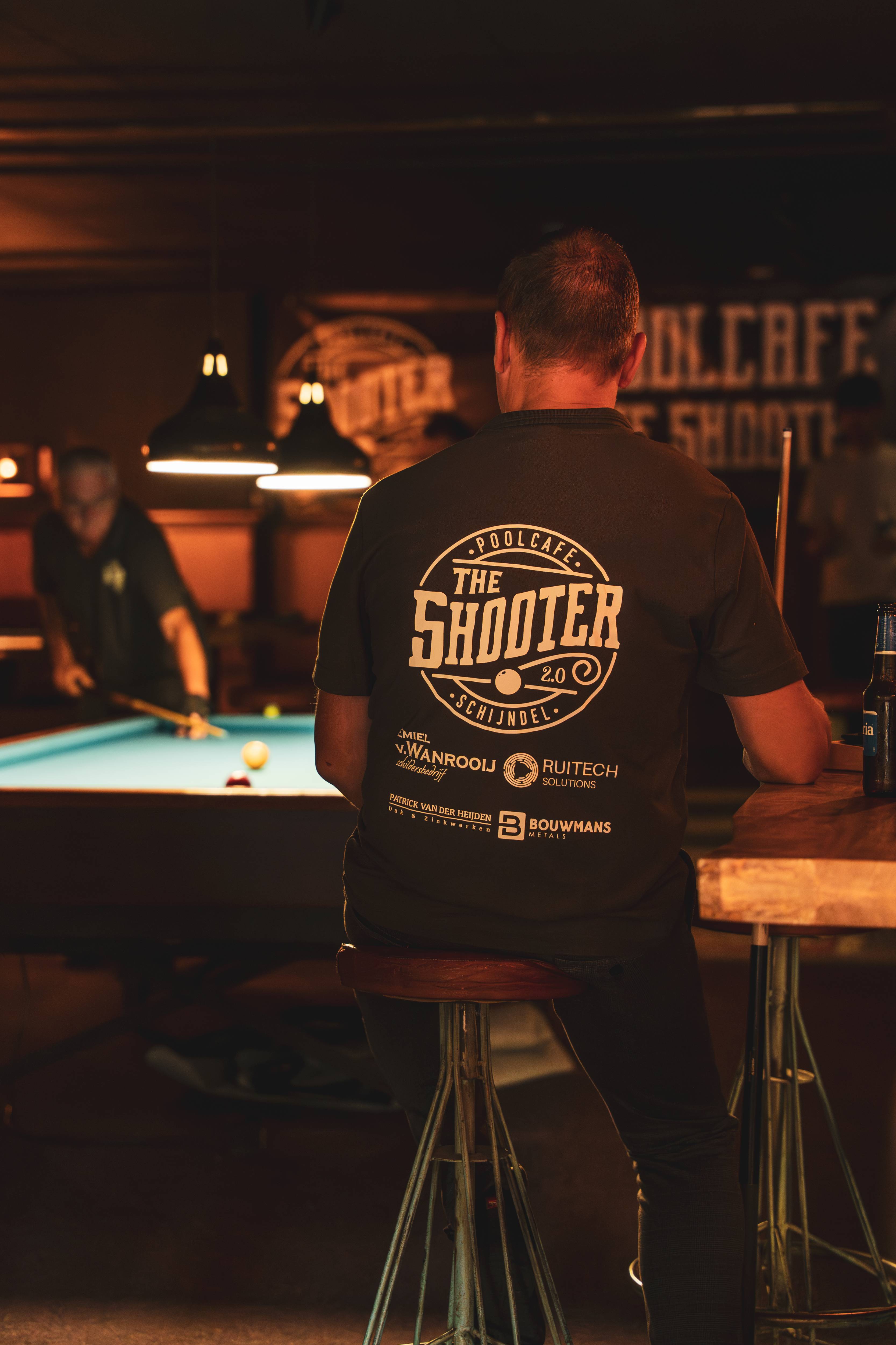 Rug van persoon met The Shooter shirt en sponsors