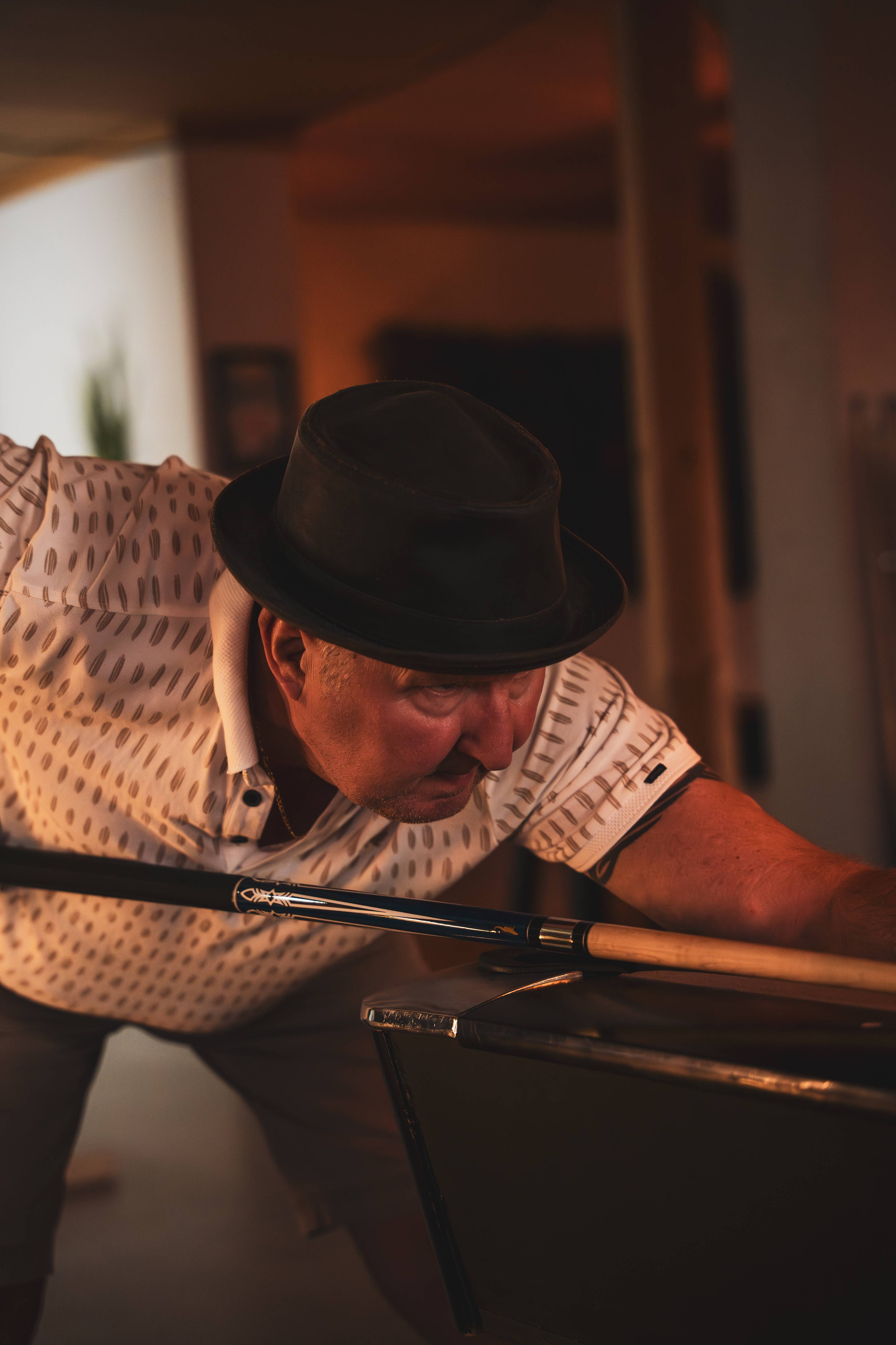 Close-up poolspeler met hoed geconcentreerd bij de tafel