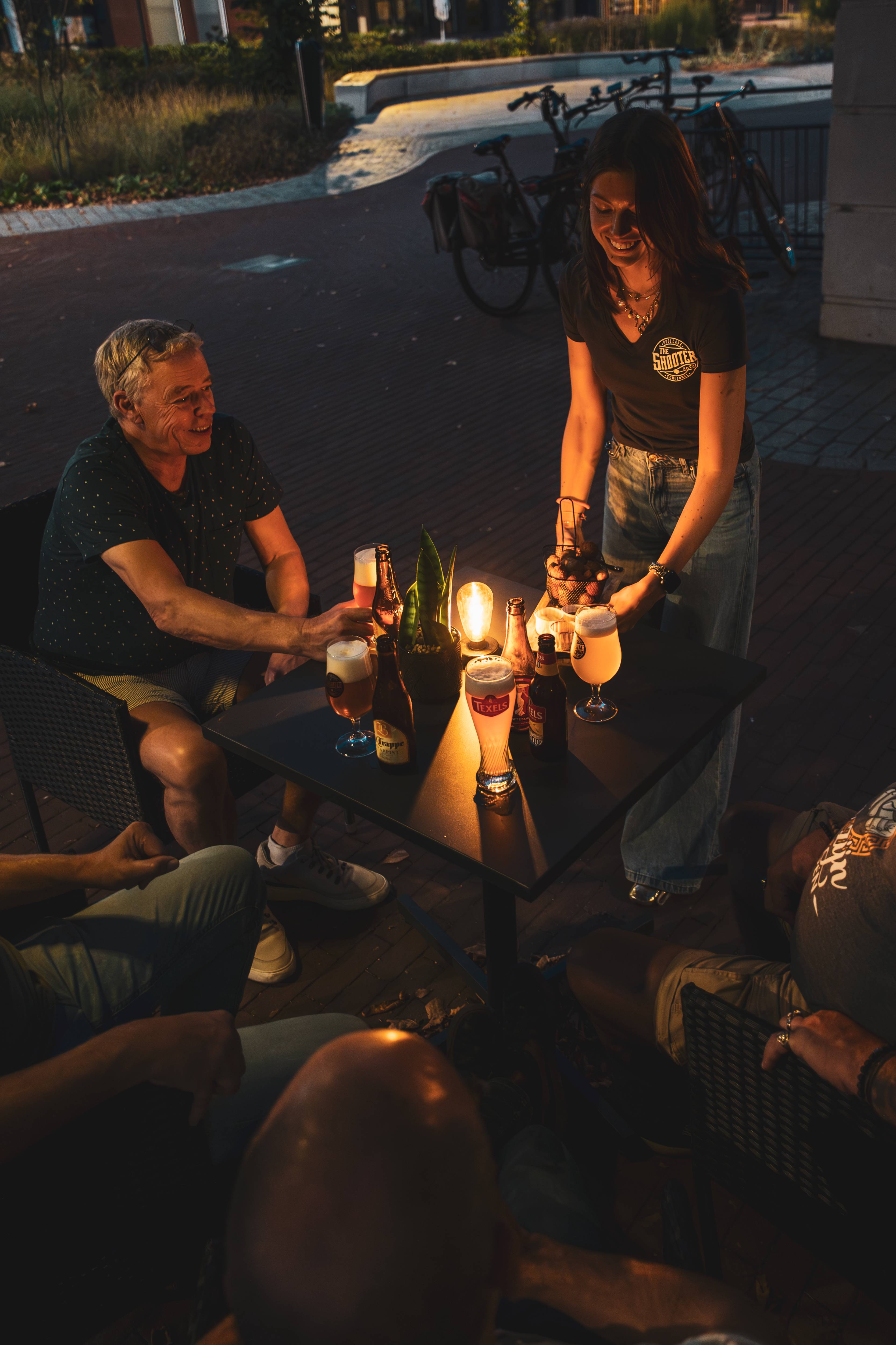 Gasten genieten op het terras bij avondlicht