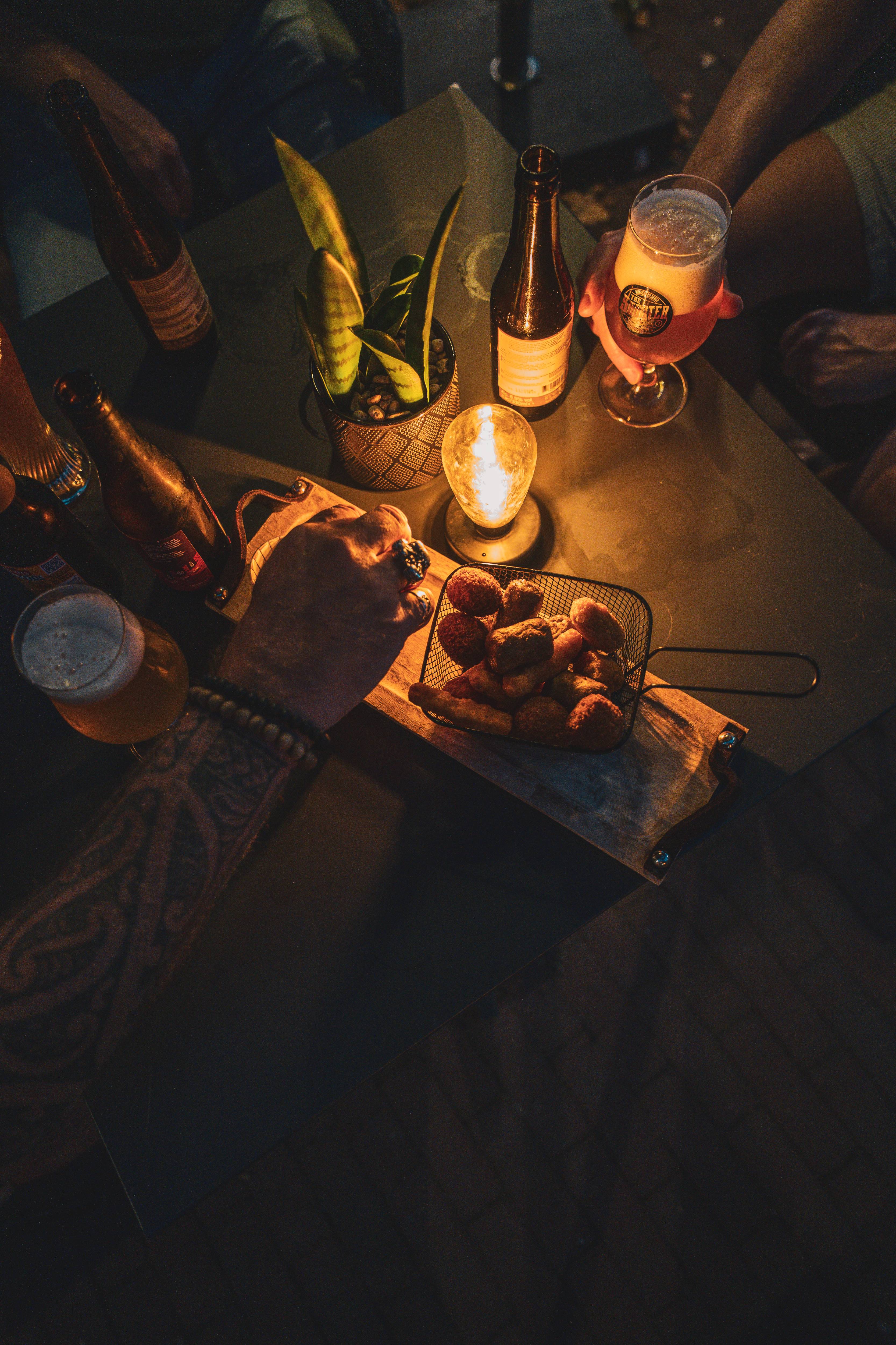 Bitterballen en speciaalbier op tafel bij kaarslicht